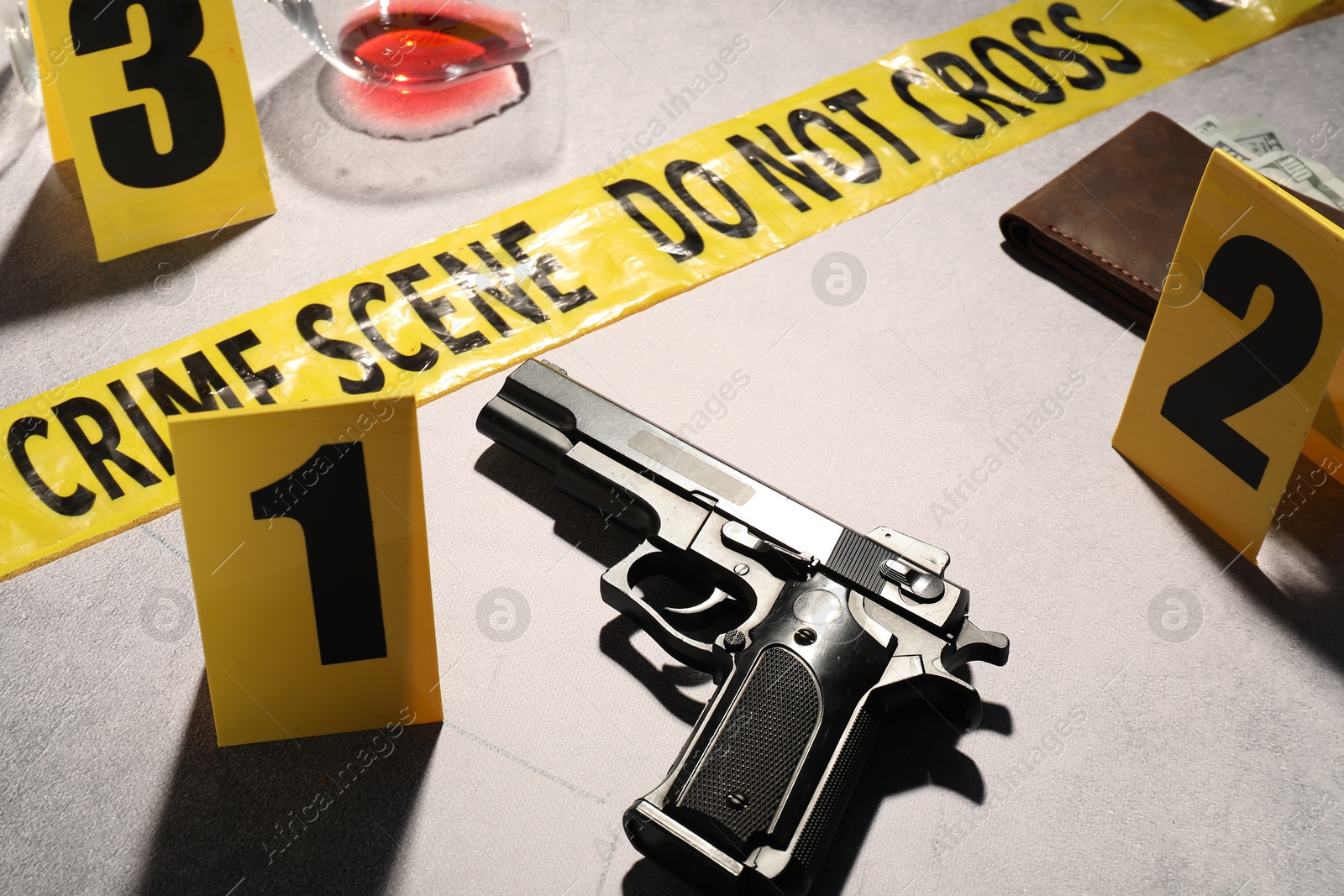 Photo of Forensic expertise. Crime scene with evidence, markers and police tape on light grey background, closeup
