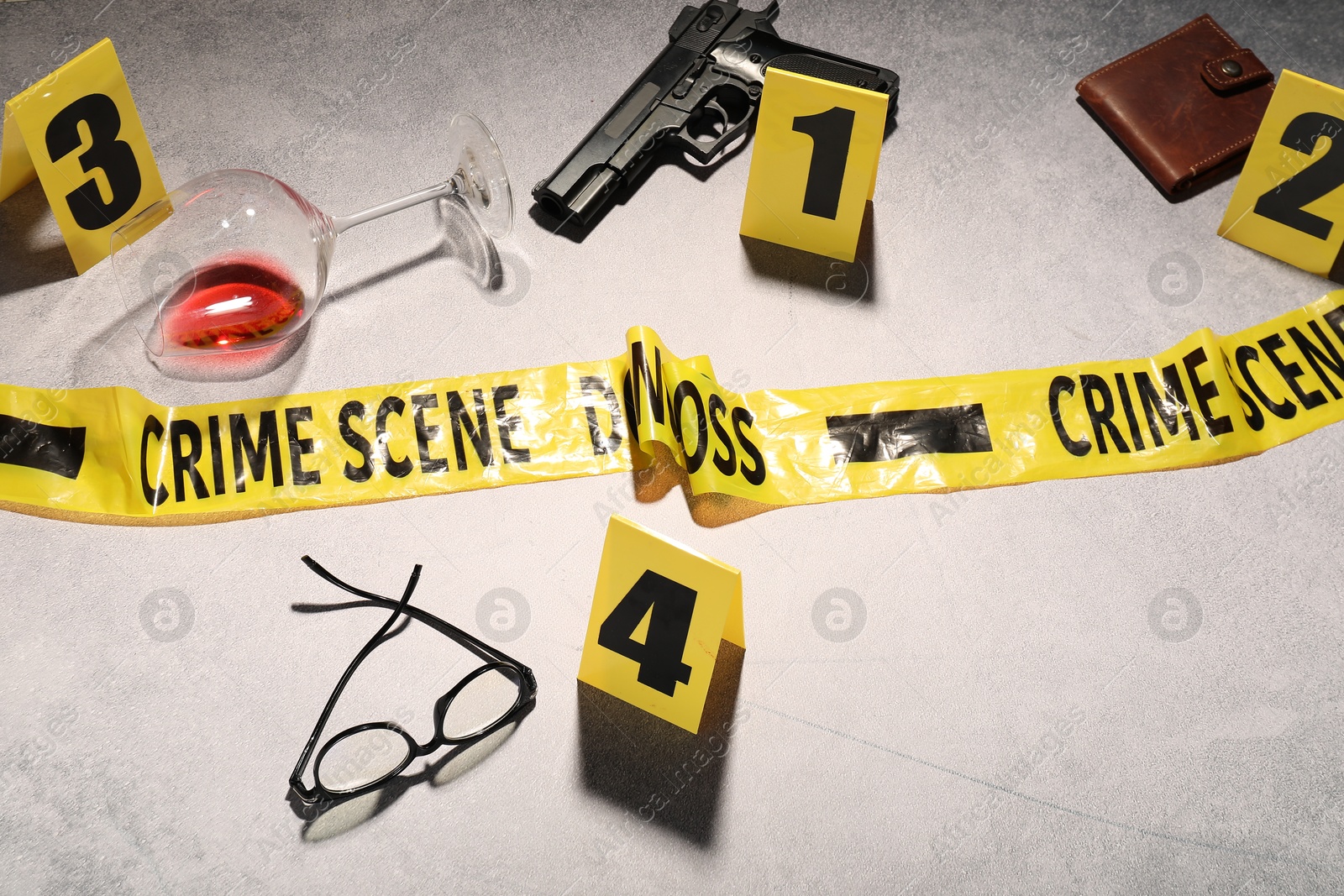 Forensic expertise. Crime scene with evidence, markers and police tape on light grey background Photo of Forensic expertise. Crime scene with evidence, markers and police tape on light grey background