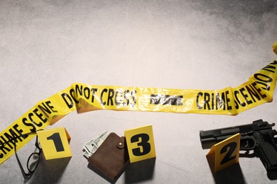Photo of Forensic expertise. Crime scene with evidence, markers and police tape on light grey background, flat lay. Space for text