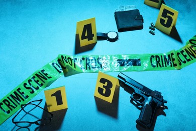 Photo of Forensic expertise. Crime scene with evidence, markers and police tape on blue background. Color toned effect