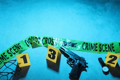 Photo of Forensic expertise. Crime scene with evidence, markers, police tape on blue background, flat lay and space for text. Color toned effect