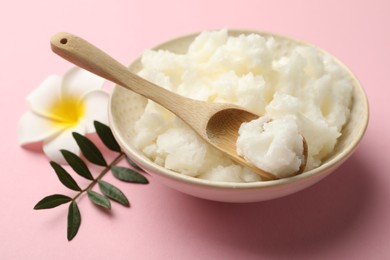Photo of Natural shea butter, plumeria flower and leaves on pink background, closeup