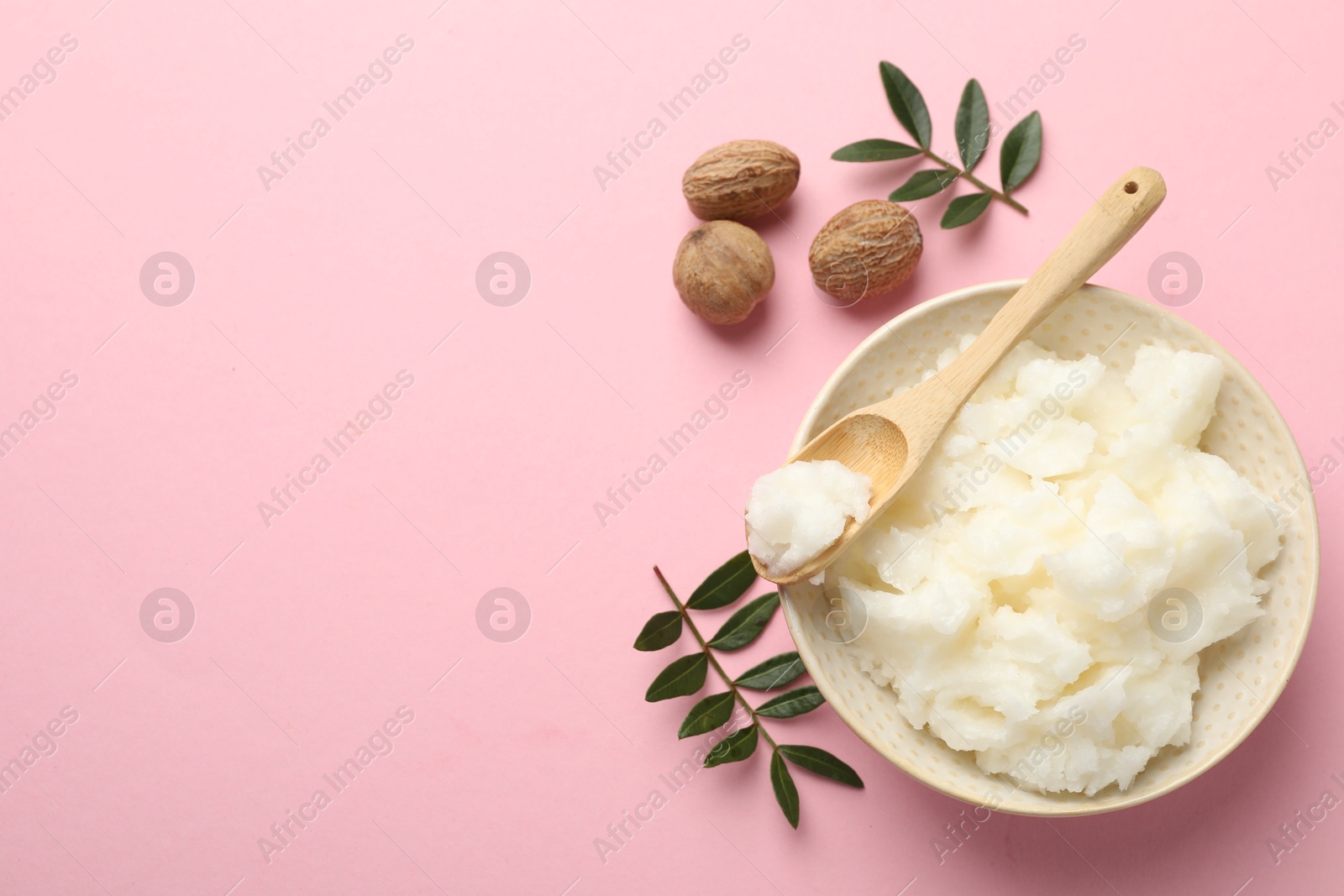 Natural shea butter, nuts and leaves on pink background, flat lay. Space for text Photo of Natural shea butter, nuts and leaves on pink background, flat lay. Space for text