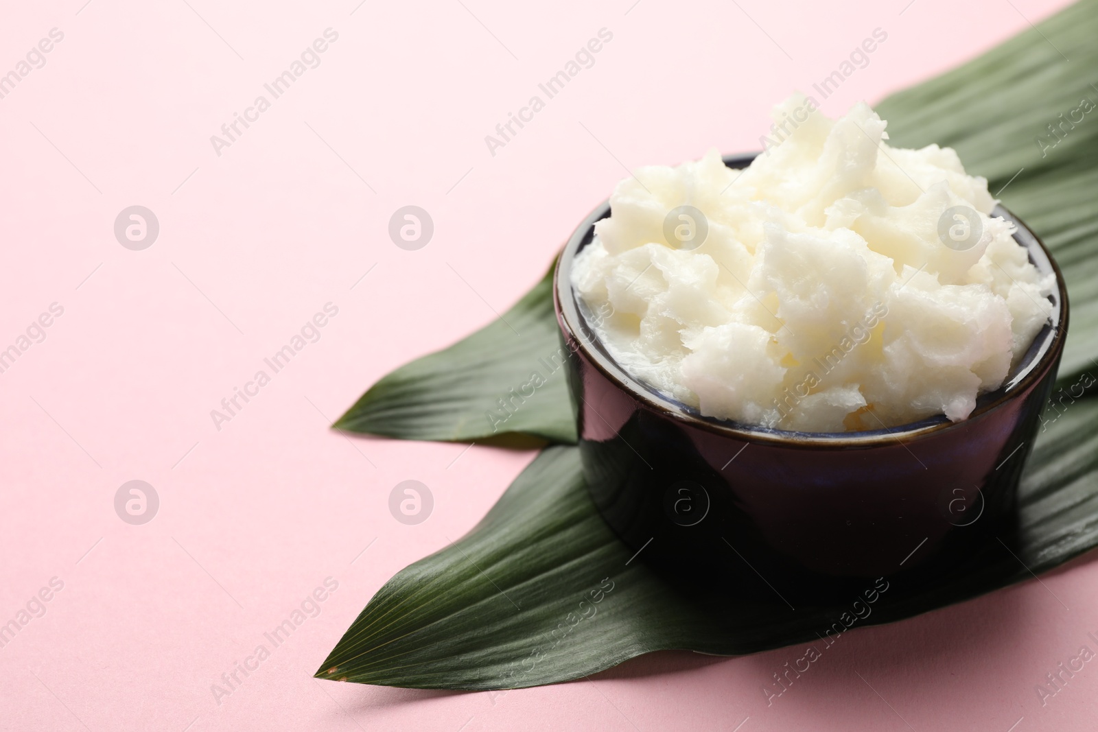 Natural shea butter and leaves on pink background, closeup. Space for text Photo of Natural shea butter and leaves on pink background, closeup. Space for text