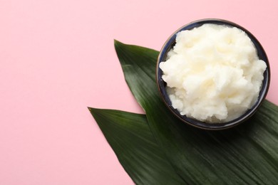 Photo of Natural shea butter and leaves on pink background, top view. Space for text
