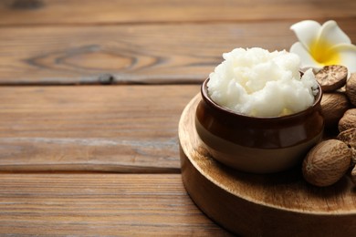 Photo of Natural shea butter on wooden table, closeup. Space for text