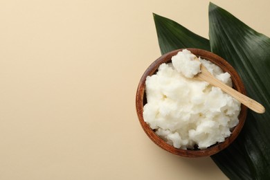 Photo of Natural shea butter and leaves on beige background, top view. Space for text