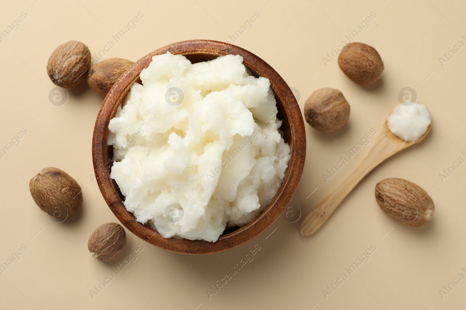 Natural shea butter and nuts on beige background, flat lay Photo of Natural shea butter and nuts on beige background, flat lay