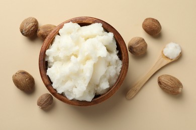 Photo of Natural shea butter and nuts on beige background, flat lay