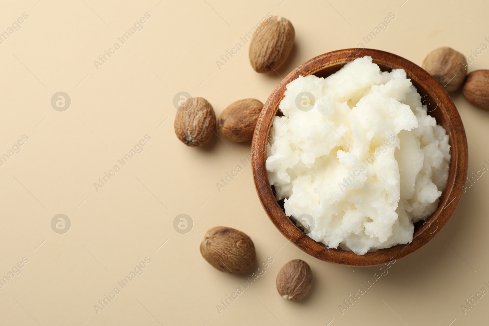 Natural shea butter and nuts on beige background, flat lay. Space for text Photo of Natural shea butter and nuts on beige background, flat lay. Space for text