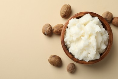 Photo of Natural shea butter and nuts on beige background, flat lay. Space for text