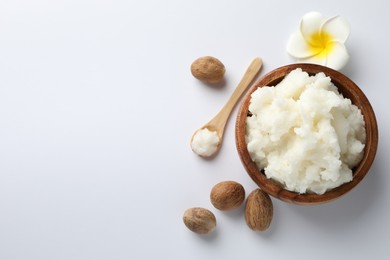 Photo of Natural shea butter, nuts and plumeria flower on white background, flat lay. Space for text