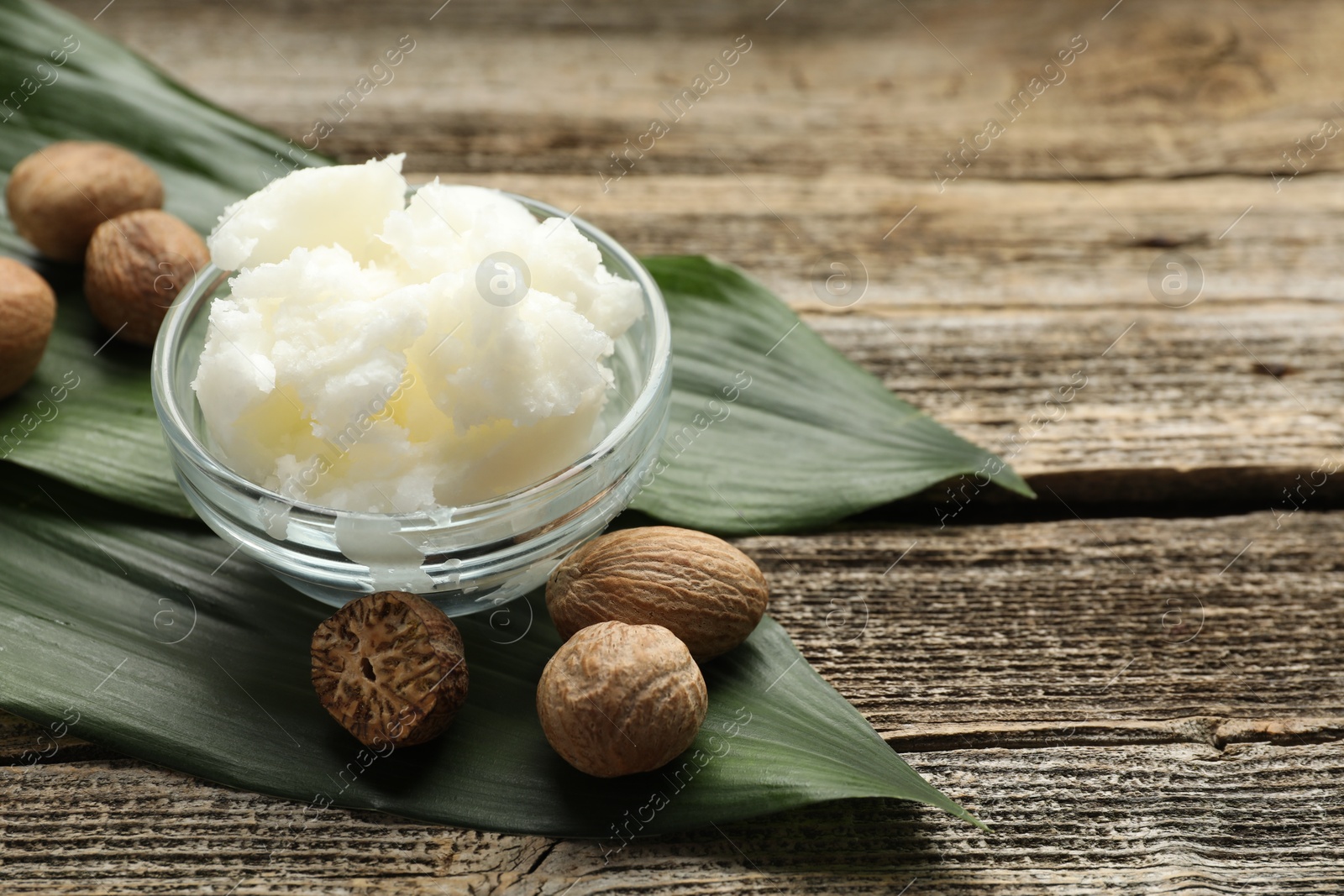 Natural shea butter and nuts on wooden table, closeup. Space for text Photo of Natural shea butter and nuts on wooden table, closeup. Space for text