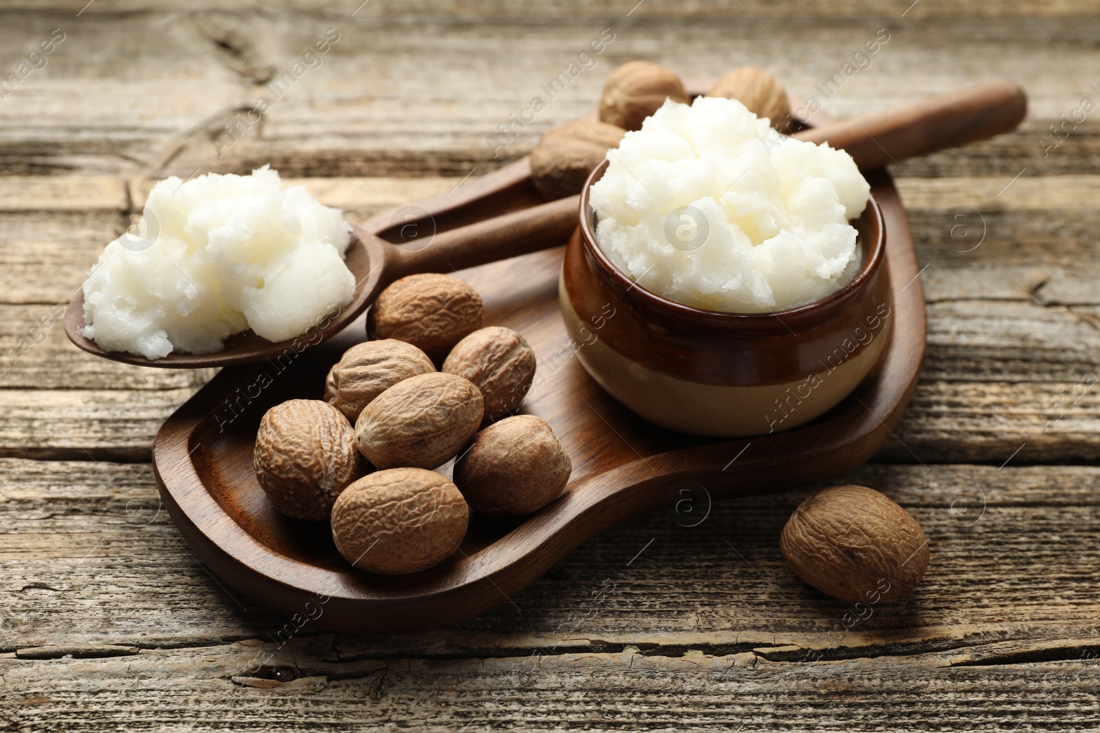 Natural shea butter and nuts on wooden table, closeup Photo of Natural shea butter and nuts on wooden table, closeup