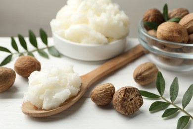 Photo of Natural shea butter on white wooden table, closeup