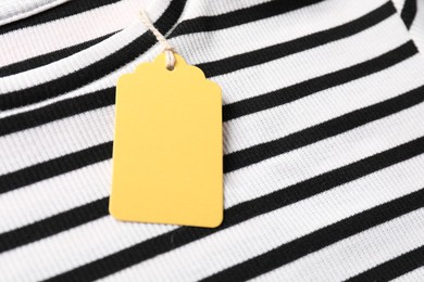Photo of Cardboard tag on striped t-shirt, closeup view