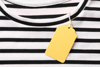 Photo of Cardboard tag on striped t-shirt, top view