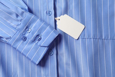 Photo of Cardboard tag on light blue shirt, top view
