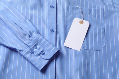 Photo of Cardboard tag on light blue shirt, top view