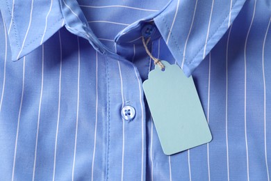 Photo of Cardboard tag on light blue shirt, top view
