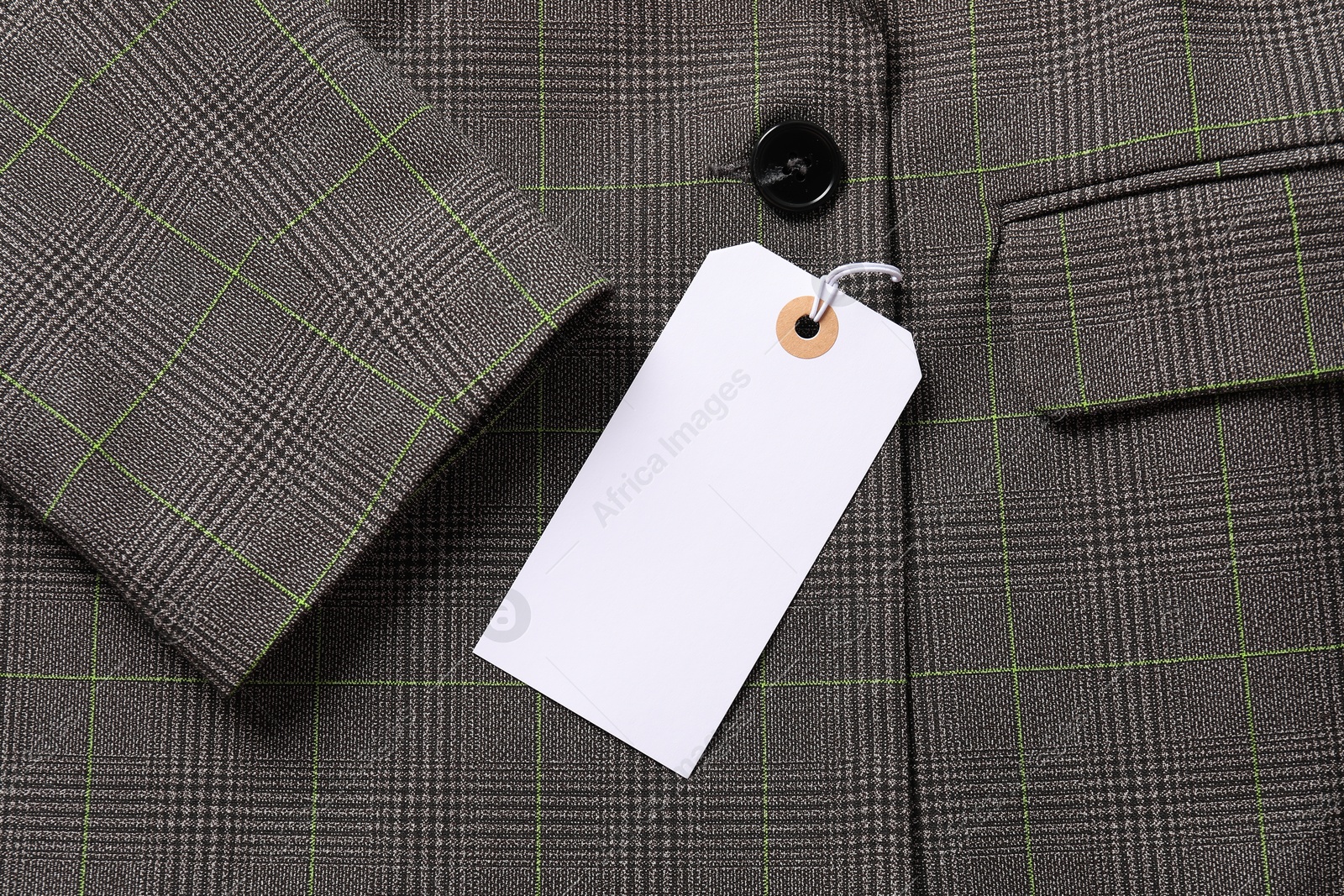 Cardboard tag on grey jacket, top view Photo of Cardboard tag on grey jacket, top view