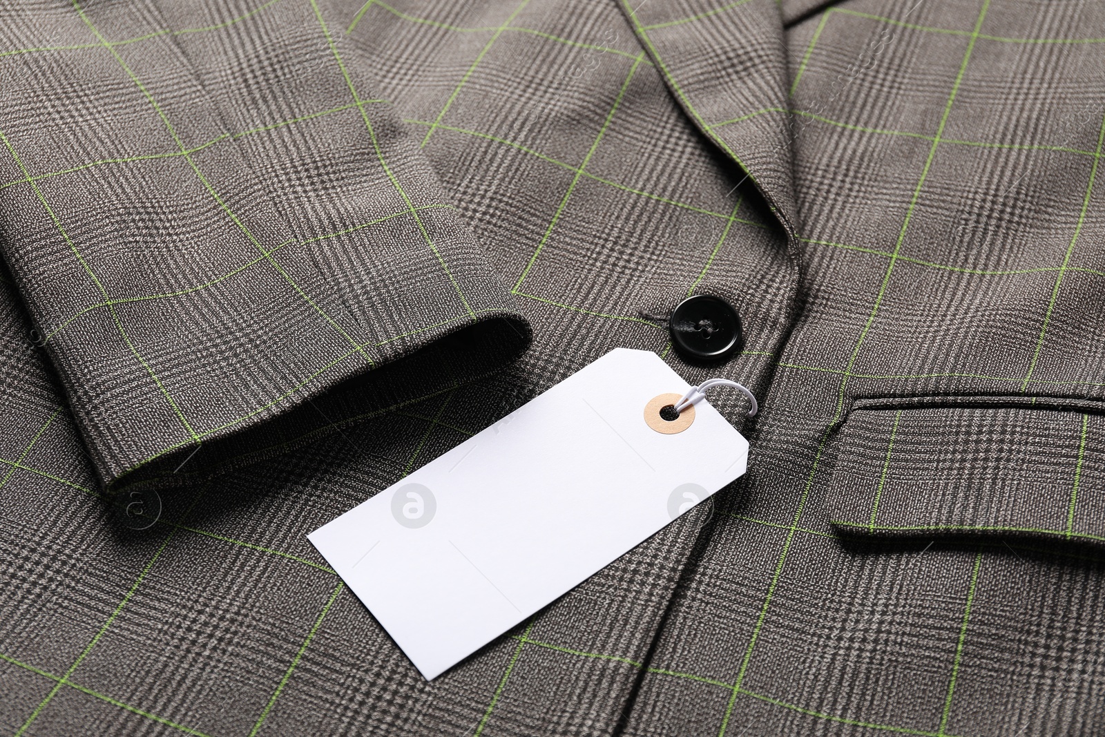 Cardboard tag on grey jacket, closeup view Photo of Cardboard tag on grey jacket, closeup view