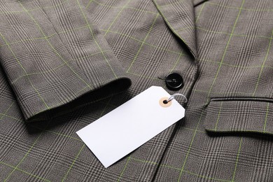 Photo of Cardboard tag on grey jacket, closeup view