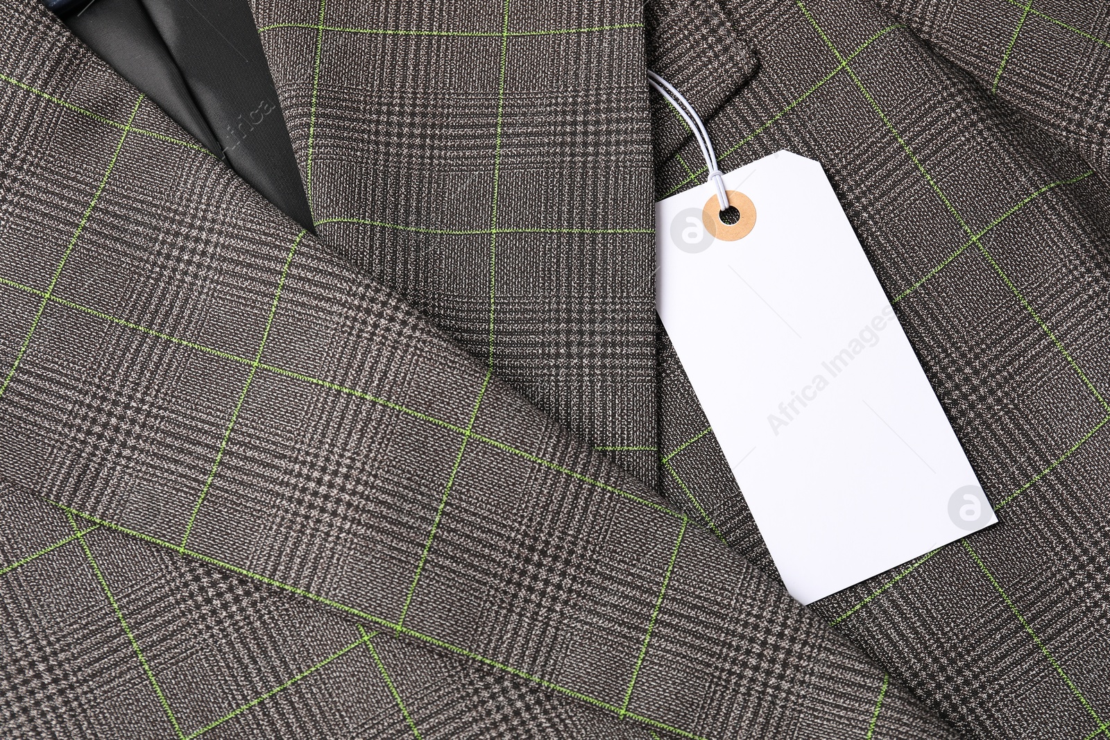 Cardboard tag on grey jacket, top view Photo of Cardboard tag on grey jacket, top view