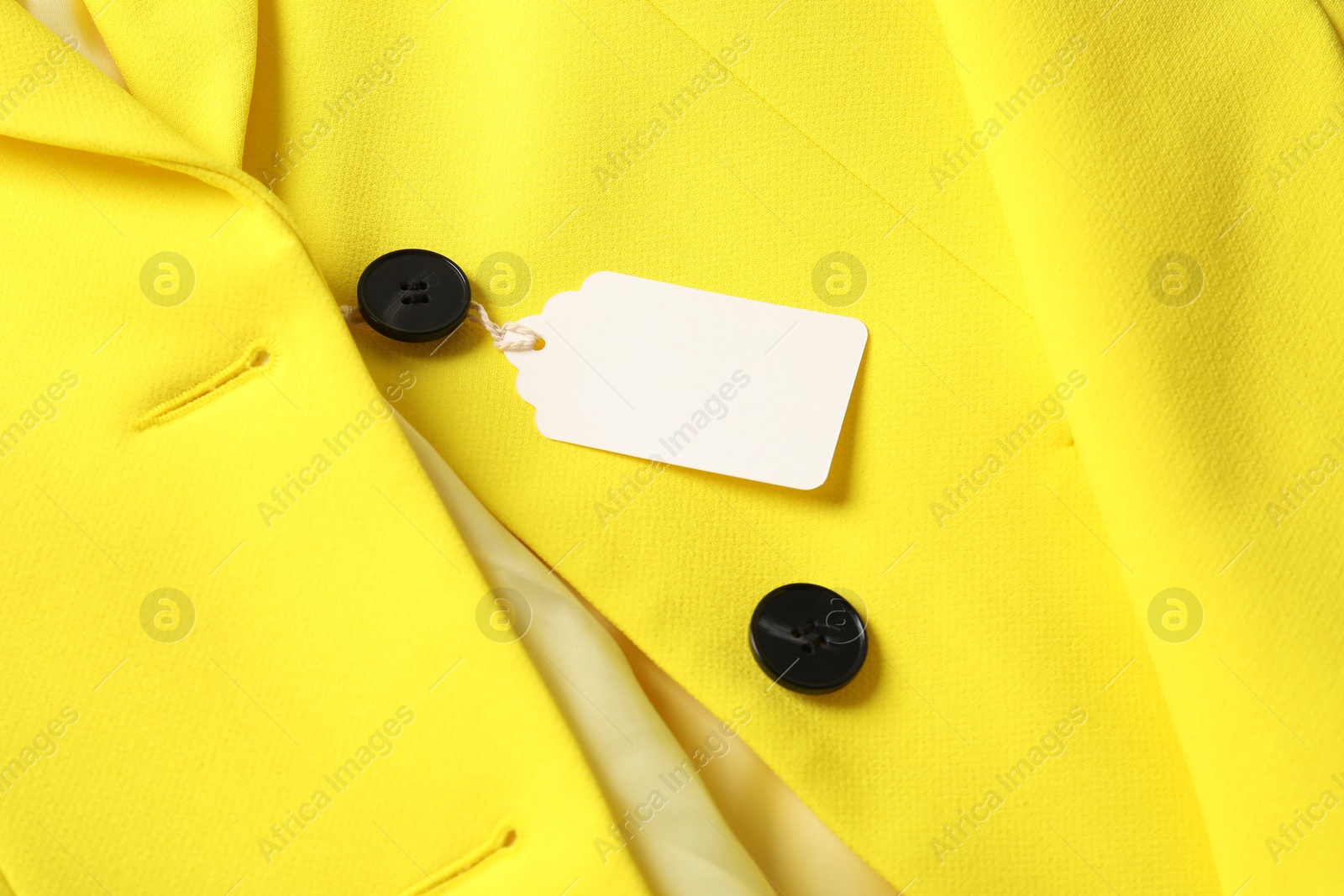 Cardboard tag on yellow jacket, above view Photo of Cardboard tag on yellow jacket, above view