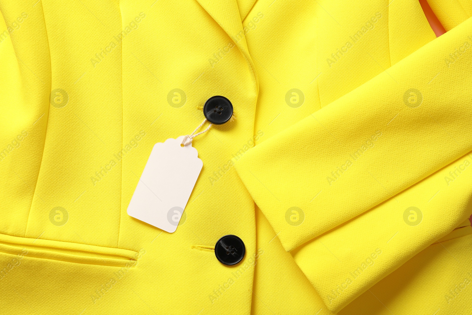 Cardboard tag on yellow jacket, top view Photo of Cardboard tag on yellow jacket, top view