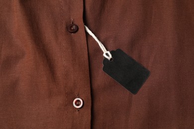 Photo of Cardboard tag on brown shirt, top view