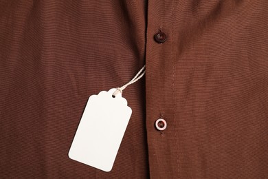Photo of Cardboard tag on brown shirt, top view