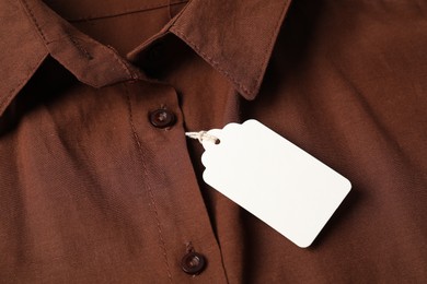 Photo of Cardboard tag on brown shirt, above view