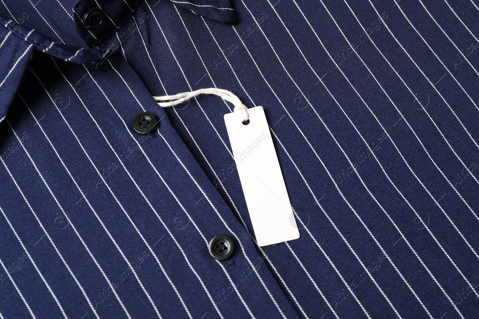 Cardboard tag on striped shirt, top view Photo of Cardboard tag on striped shirt, top view