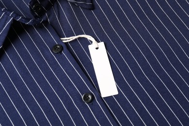 Photo of Cardboard tag on striped shirt, top view