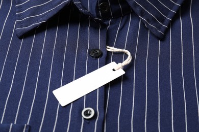 Photo of Cardboard tag on striped shirt, closeup view