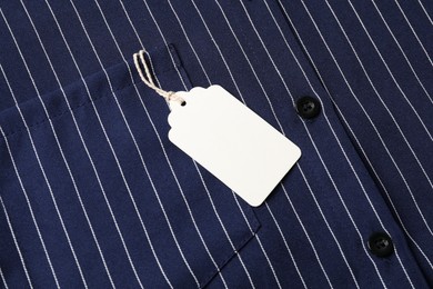 Photo of Cardboard tag on striped shirt, top view