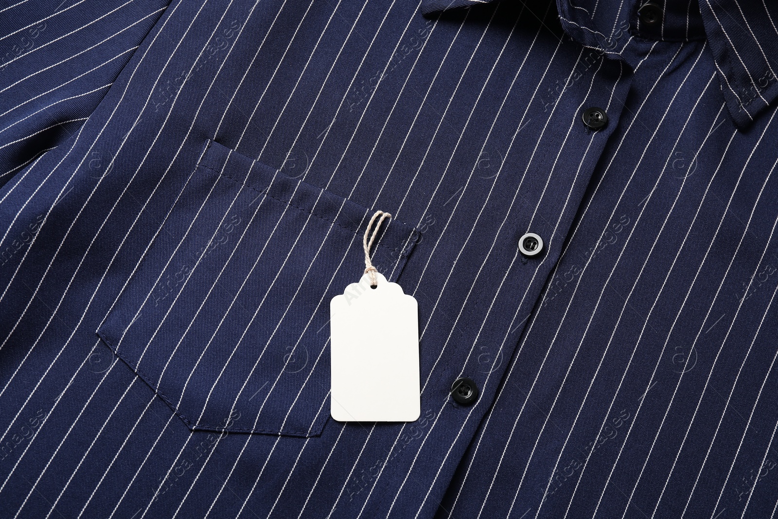 Cardboard tag on striped shirt, top view Photo of Cardboard tag on striped shirt, top view
