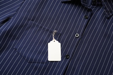 Photo of Cardboard tag on striped shirt, top view