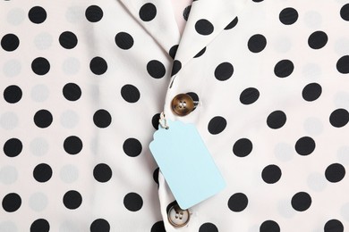 Photo of Cardboard tag on dotted shirt, top view