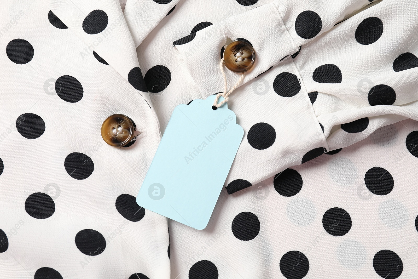 Cardboard tag on dotted shirt, top view Photo of Cardboard tag on dotted shirt, top view