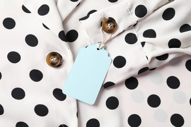 Photo of Cardboard tag on dotted shirt, top view
