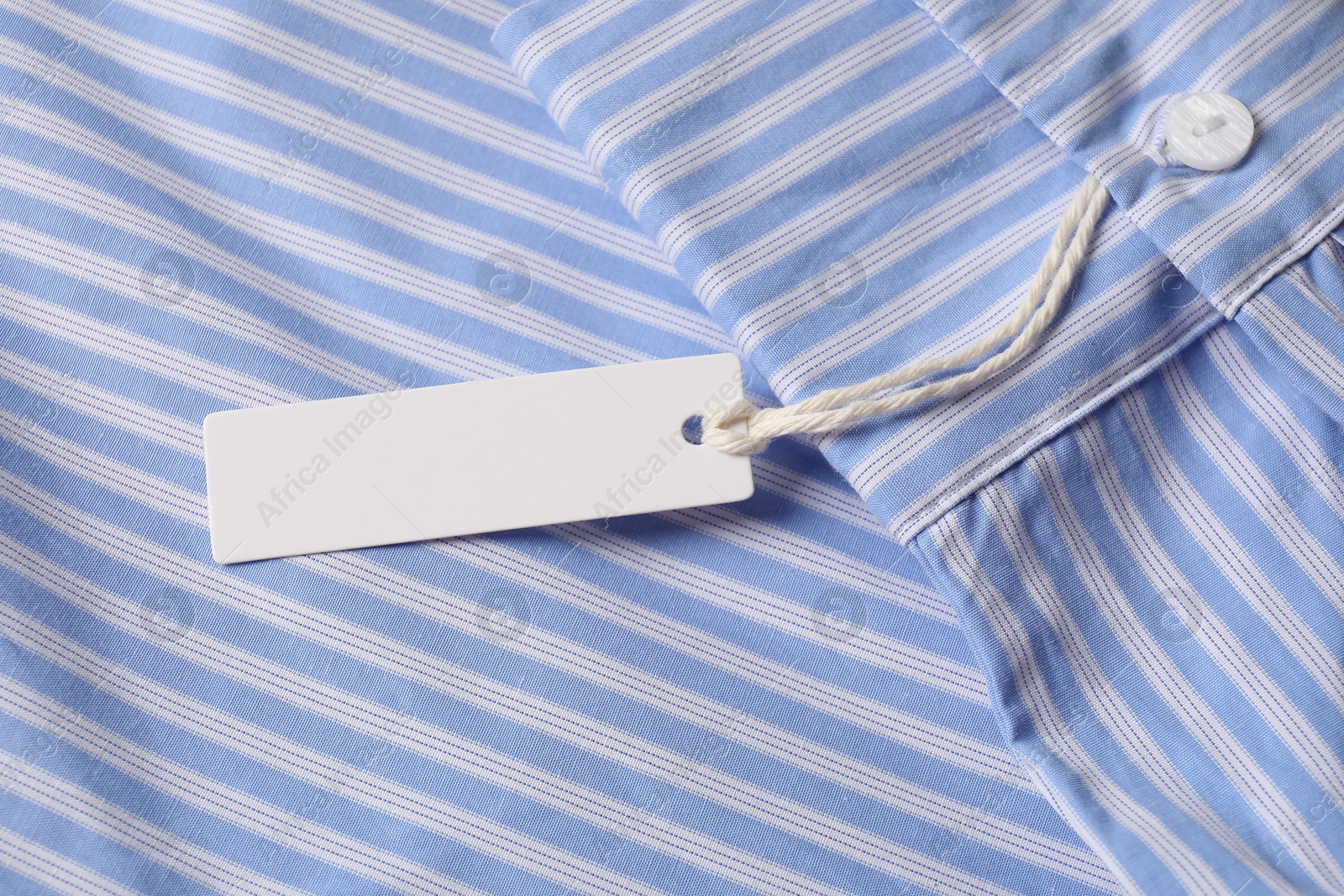 Cardboard tag on striped shirt, above view Photo of Cardboard tag on striped shirt, above view