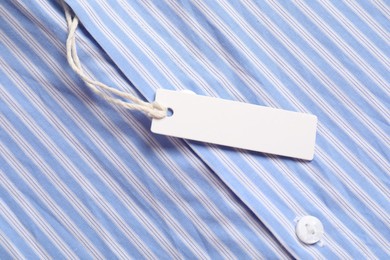 Photo of Cardboard tag on striped shirt, top view