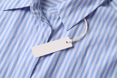 Photo of Cardboard tag on striped shirt, top view