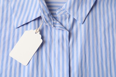 Photo of Cardboard tag on striped shirt, top view