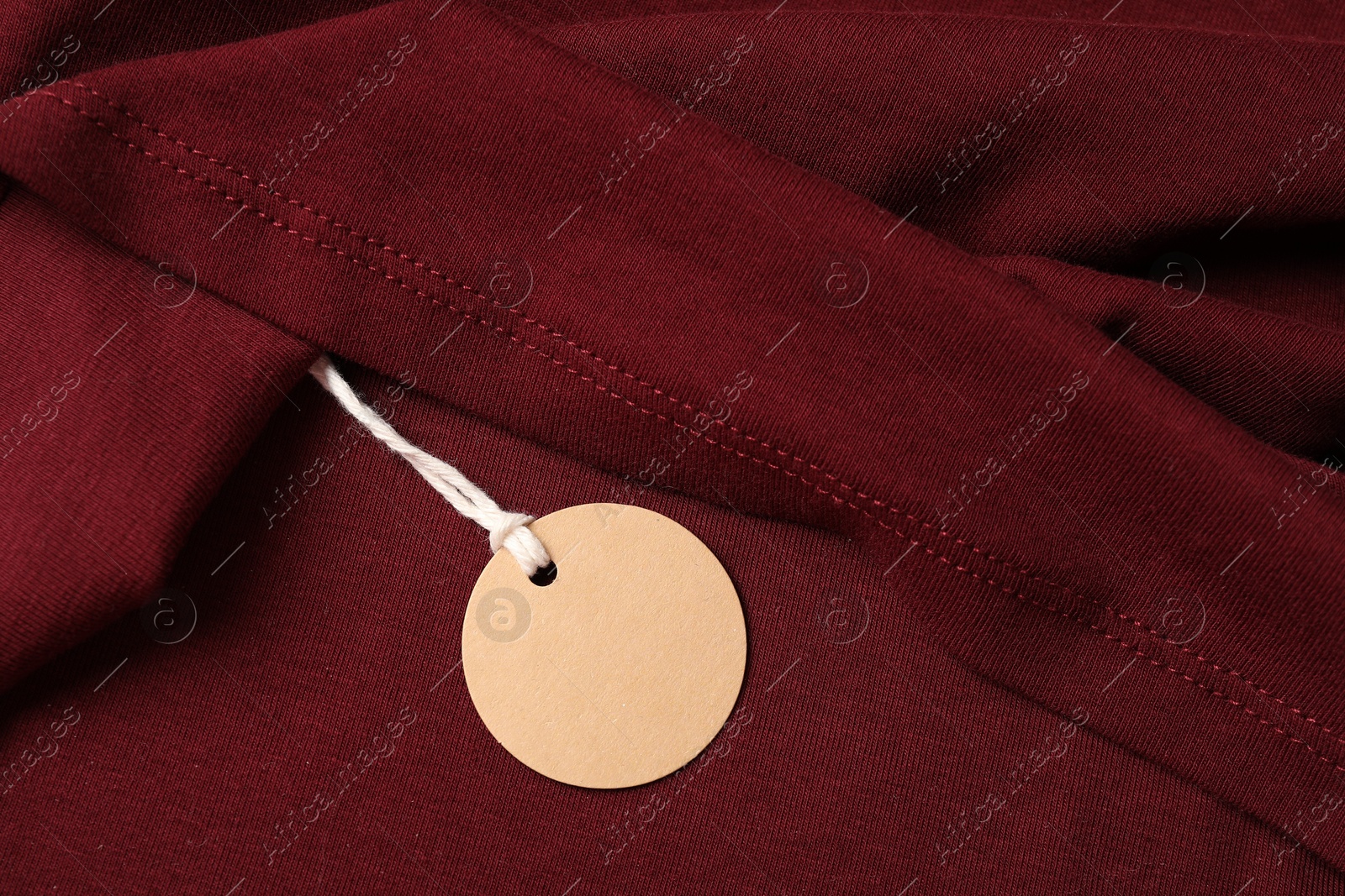 Cardboard tag on red garment, top view Photo of Cardboard tag on red garment, top view