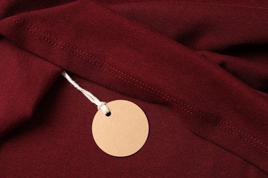 Photo of Cardboard tag on red garment, top view
