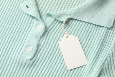 Photo of Cardboard tag on turquoise garment, above view