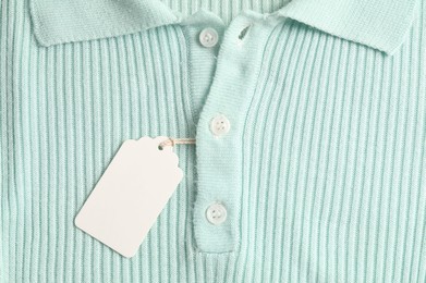 Photo of Cardboard tag on turquoise garment, top view